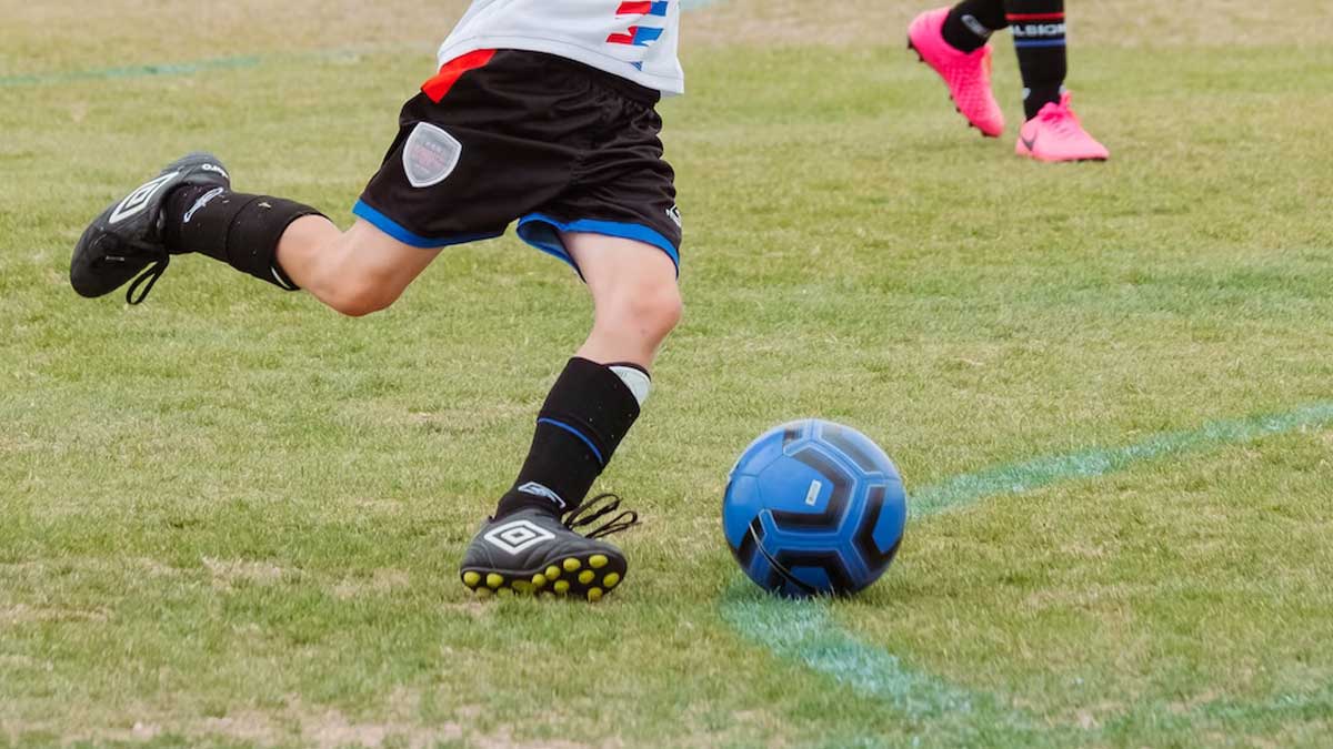 Nuori urheilija pelaa jalkapalloa.